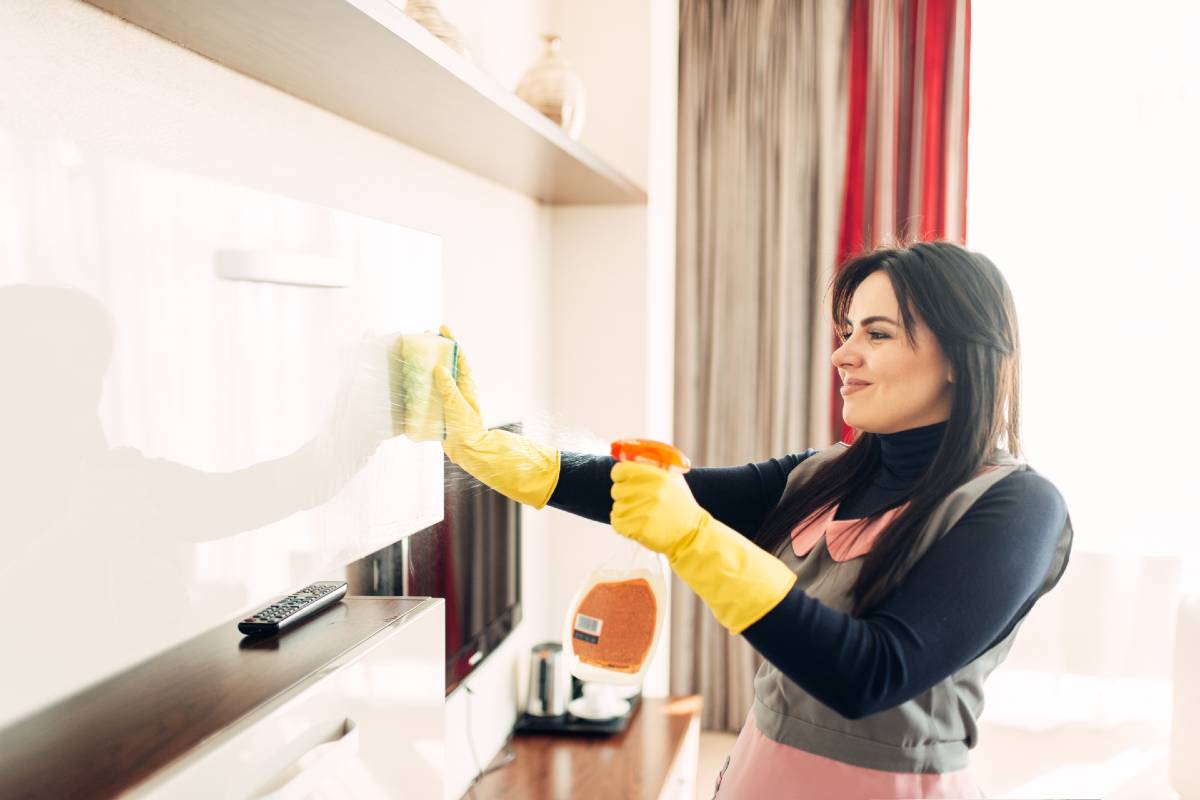 femme de ménage qui nettoie meubles de cuisine